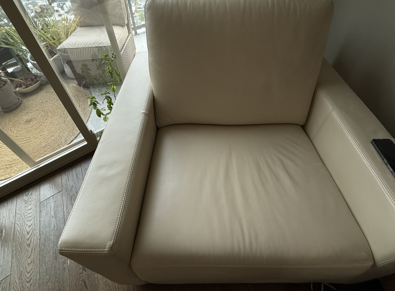 White leather armchair after professional cleaning and conditioning, fabric bright and even throughout