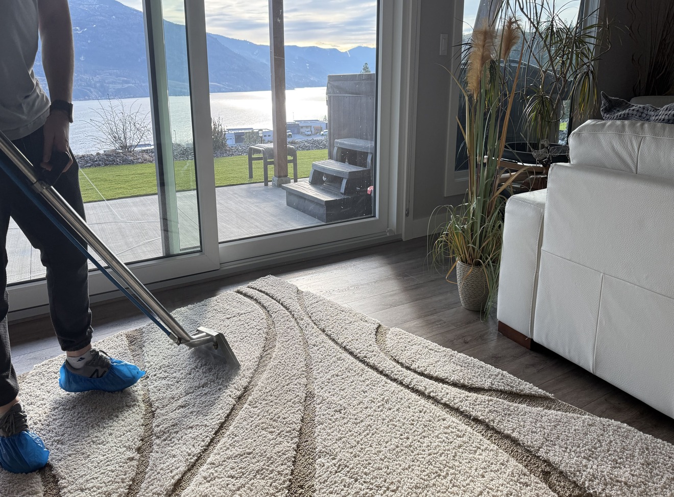 BreezeCo technician cleaning a high-pile synthetic rug with hot water extraction in a Penticton home