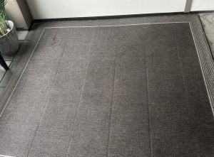 Dark carpet with visible traffic lane before professional cleaning in Kelowna