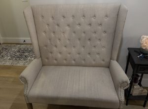 Loveseat seat cushion before cleaning - heavy soiling visible, fabric noticeably darker than surrounding upholstery